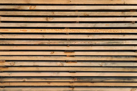Storage timber. Lumber yard.Stack of pile wood bar in lumber yard factory use for construction wood industry. Stock of timber wood construction in warehouse.