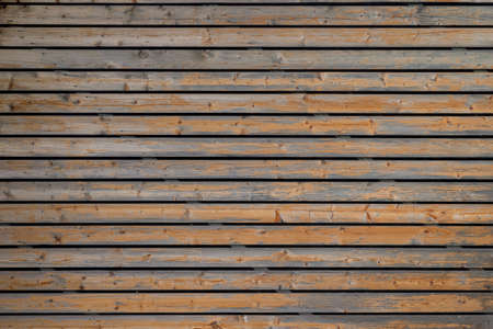 Texture of the wall covered with old wooden slats.